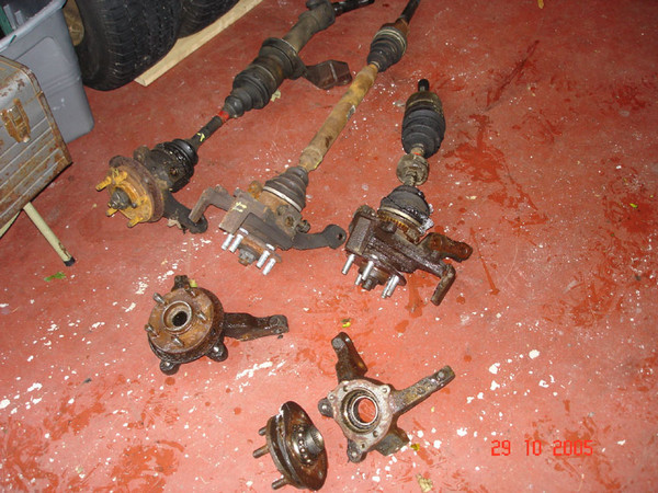 Bottom to top: two old-style steering knuckles (note the separated bearing); two new-style steering knuckles (with driveshafts); equal-length driveshaft assembly.  I wish I had remembered the big socket to separate the axles from the bearings, but at least the axles went to a good home.