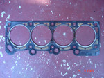 From the block-facing side, you can see where one of the coolant passages between the two middle cylinders has managed to blow through the gasket.