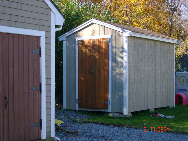 The textured plywood siding alone absorbed three gallons for two coats; it had been weathered, untreated, for two years.
