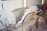 Passenger fender in bare metal being repaired before priming.