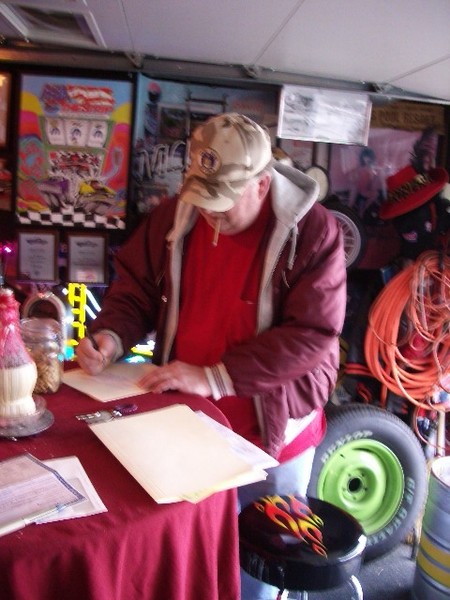 The new owner Brian signs the papers to his dream machine.