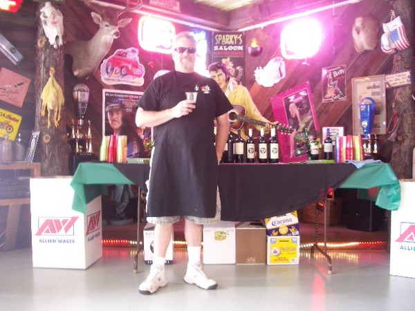 A proud young man stands ready to give his all to the BBQ.