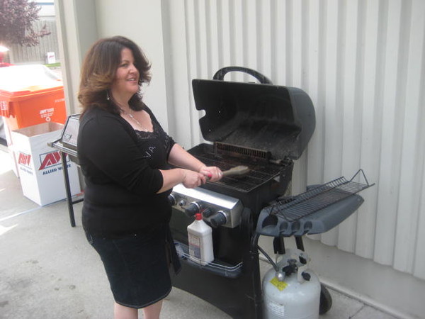 Sally cleans the grill.